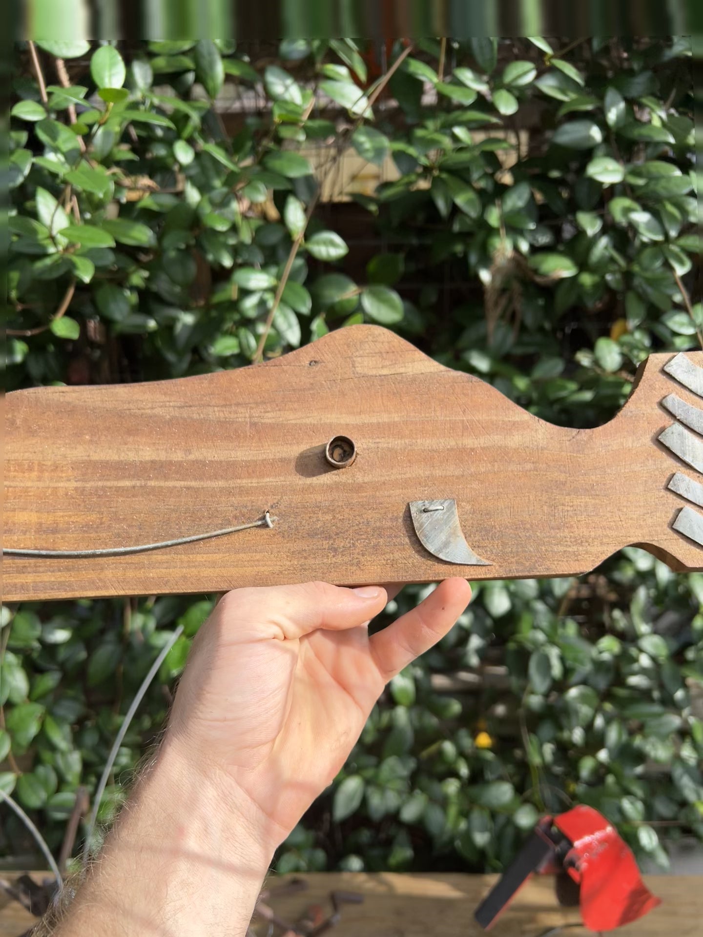 Front view of Whale Wood Art II, highlighting its rustic wooden body and galvanized steel fins